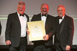 Chairman Kevin Broom und Australian Golden Outback CEO Jac Eebeek überreichen Alf Caputo den Tourismus-Award 2012 in Gold