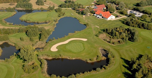 Abwechslungsreiches, naturnahes Platzlayout mit dem Clubhaus als Farbtupfer - Photocredit: Achimer GC