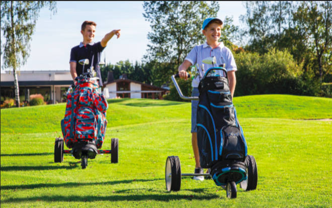 Beide Teenager fahren einen Junior Caddys Titan 3-rädrig mit Golfbag Camouflage (li.) und Golfbag Spirit (re.). 