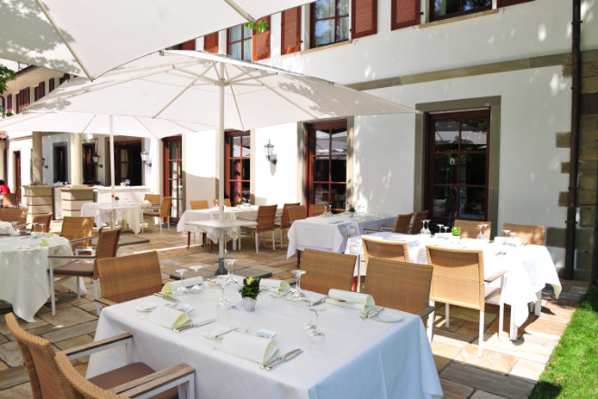 Die Hotel-Terrasse wird für Frühstück und Dinner genutzt. Das Gourmet-Restaurant versteckt sich hinter den rechten bodentiefen Fenstern.