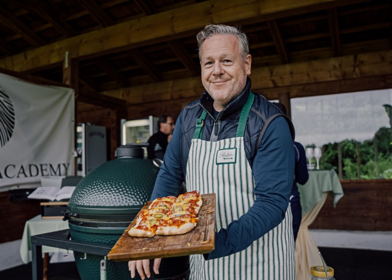 Florian Knecht von Big Green Egg Deutschland serviert Pizzaecken vom Keramikgrill beim Auftakt der Stanglwirt Golf Trophy.